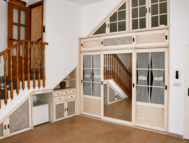 Muebles a medida para escaleras en Elche con armarios, cajones, estantes y puertas adaptadas al hueco disponible.