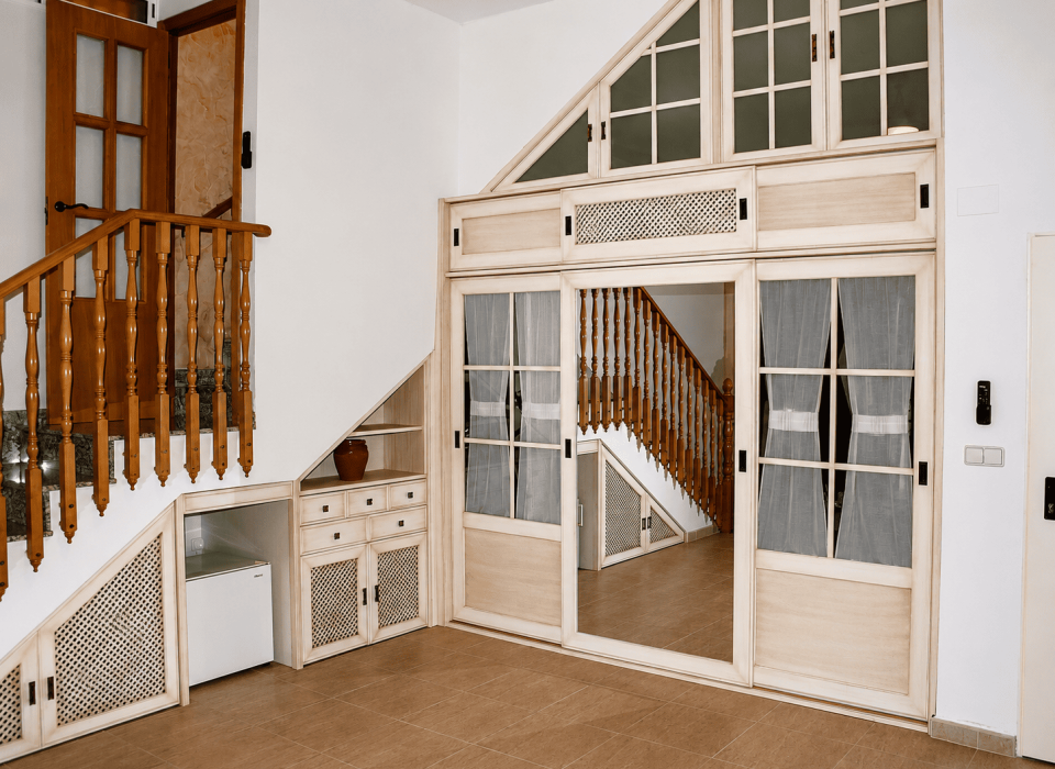 Muebles a medida para escaleras en Elche con armarios, cajones, estantes y puertas adaptadas al hueco disponible.